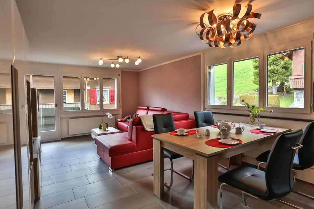 uma sala de estar com uma mesa e um sofá vermelho em Weiherhof em Wildhaus