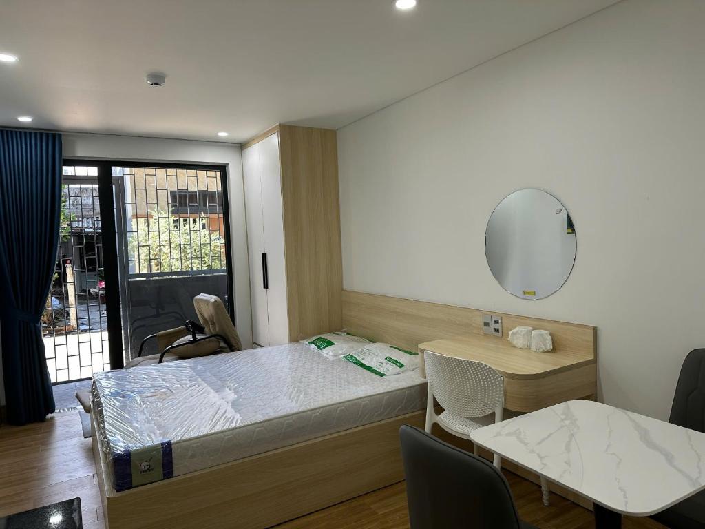 a bedroom with a bed and a table and a mirror at The Ló Apartment in Kon Rung (1)