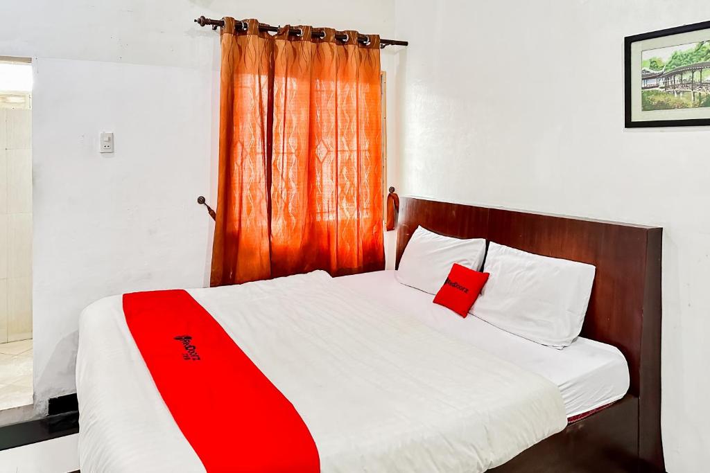 a bedroom with a bed with a red blanket on it at RedDoorz near Gajah Mada Park Medan in Medan