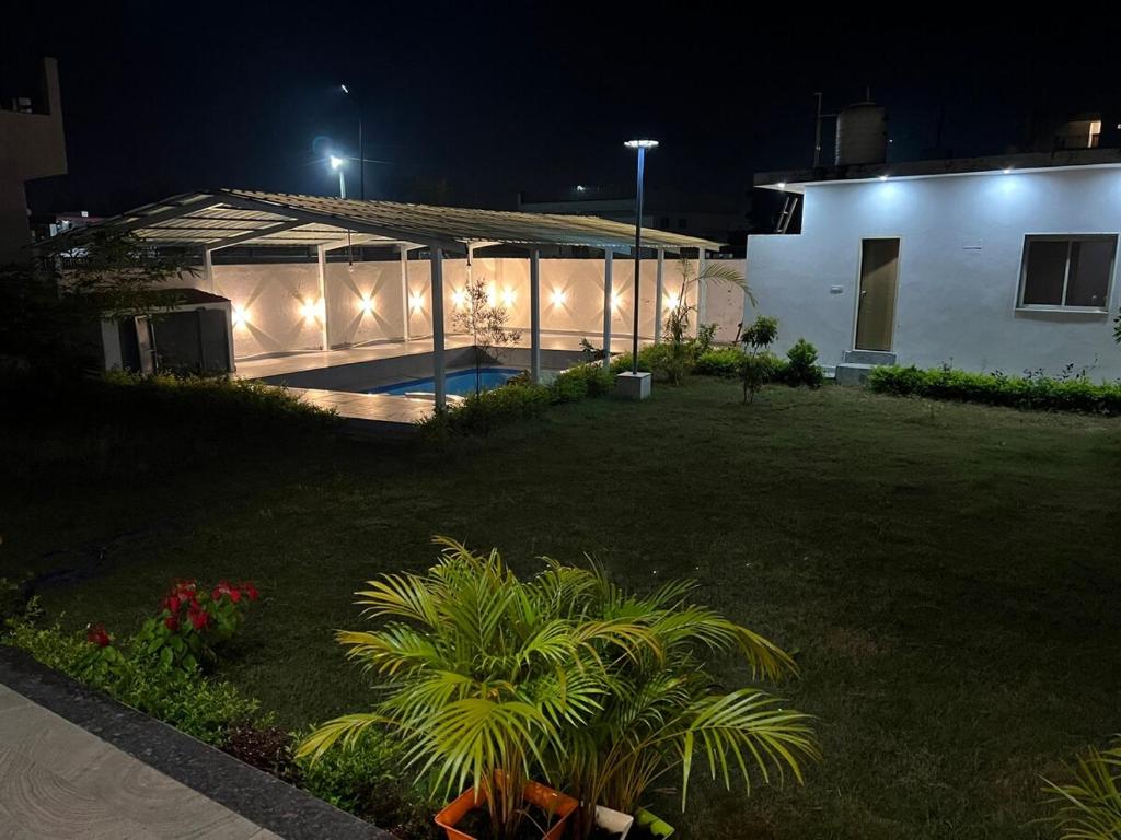 Un patio trasero de noche con un edificio y una planta en Monal by Shubhs, en Jāmb