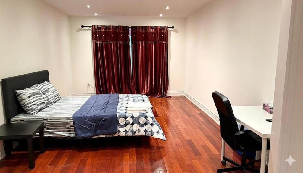 a bedroom with a bed and a desk and red curtains at Hollywell in Mississauga