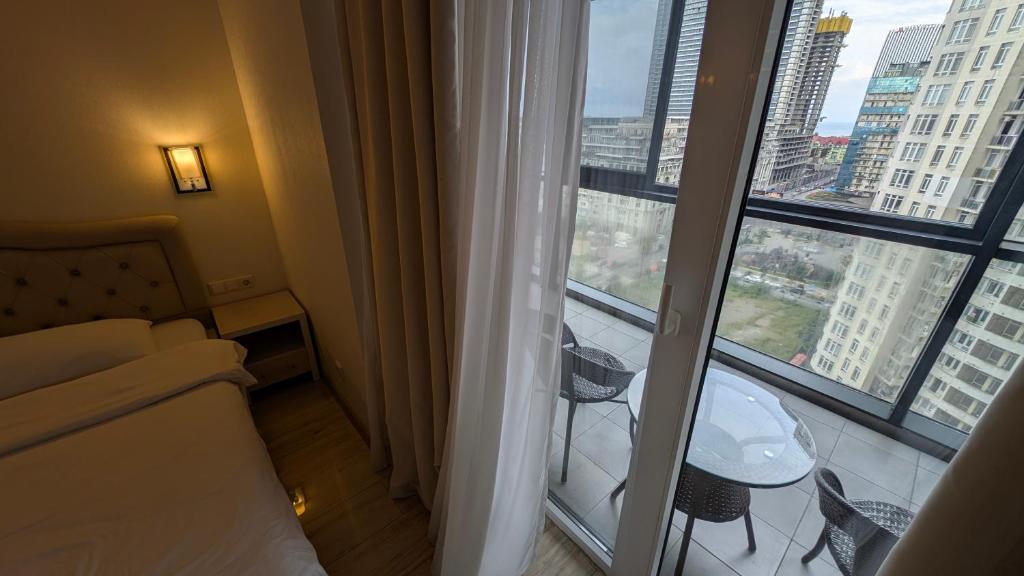 una habitación de hotel con una cama y una ventana grande en Princess in Alliance Palace, en Batumi
