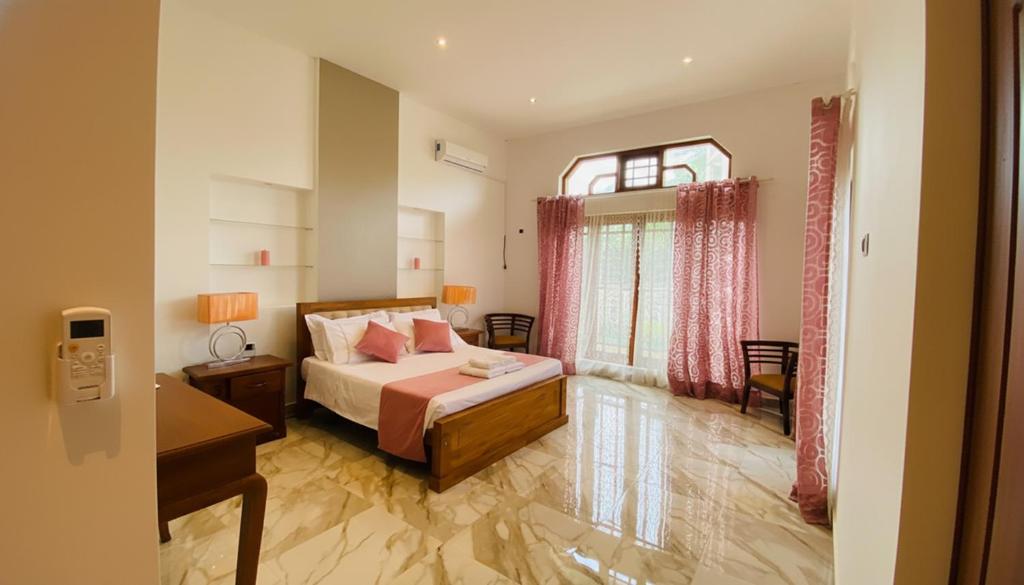 a bedroom with a bed and a window at Silva Villa Negombo in Negombo