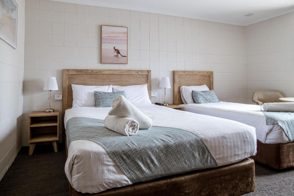 a bedroom with two beds and a dog on the wall at Hospitality Esperance SureStay Collection by Best Western in Esperance