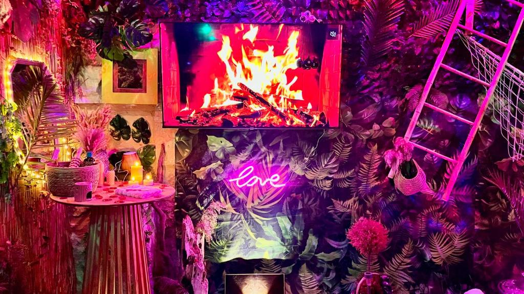 ein Raum mit einer Wand, in der ein Feuer brennt in der Unterkunft Un Mirage Tropical - Bulles , Spa & Détente en Bord de Loire in Saint-Clément-des-Levées
