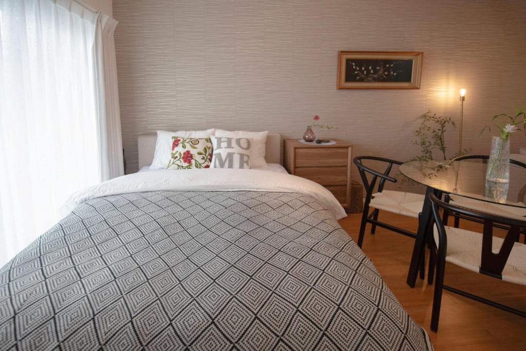 a bedroom with a large bed with a table and a table at kotinoma kuu in Hakozaki