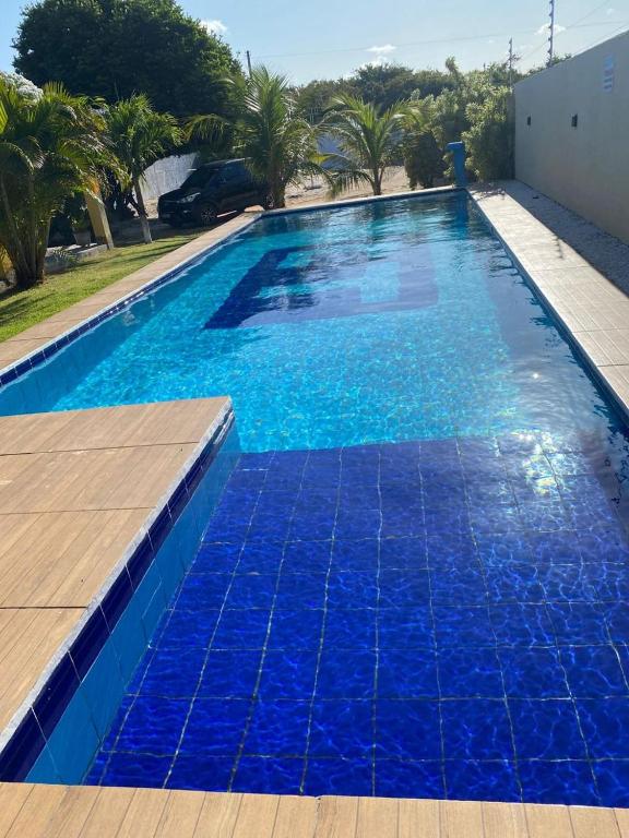 a large blue swimming pool with blue water at Casa Amarela Caponga in Cascavel