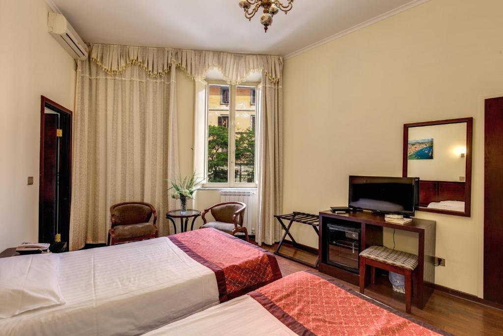 a bedroom with a bed and a desk and a television at New albatros in Rome
