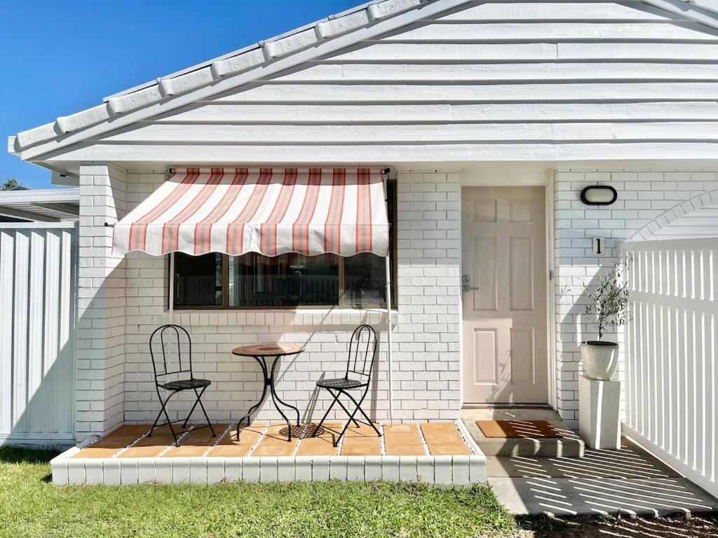 a patio with two chairs and a table under awning at Casa Al Mare- family and pet friendly, close to everything in Gold Coast