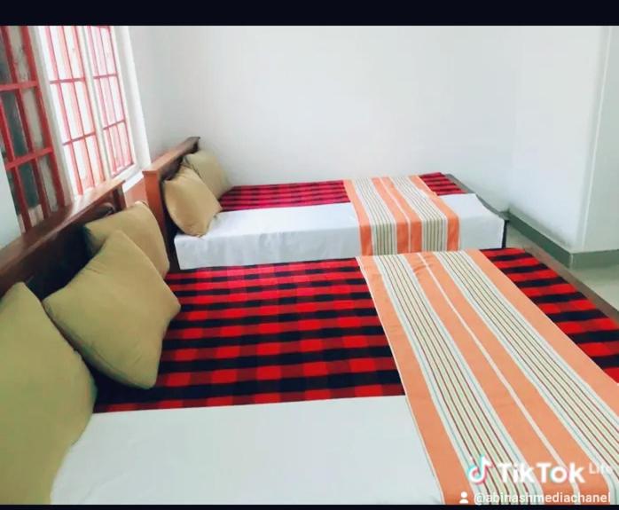 a bedroom with two twin beds in a room at NK Hotel & Resturaunt in Matale