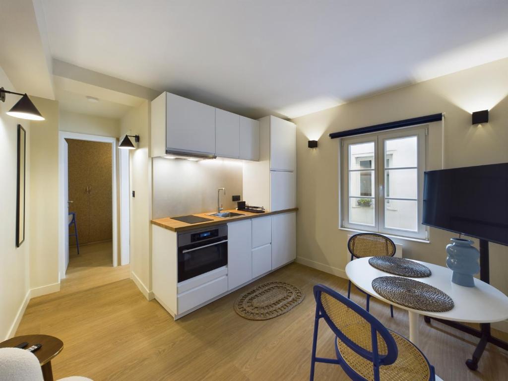 eine Küche und ein Esszimmer mit Tisch und Stühlen in der Unterkunft Charmant 2 pièces très calme aux pieds de la Cathédrale in Straßburg