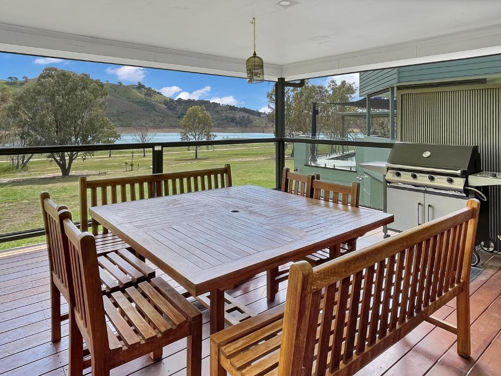 una gran terraza con mesa de madera y bancos en Eildon Views, en Bonnie Doon