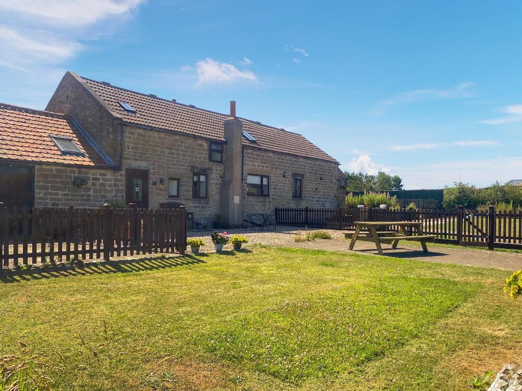 a house with a wooden fence and a picnic table at Bay - Uk44720 in Ravenscar