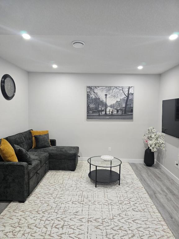 a living room with a couch and a table at Cozy on Baywater in Airdrie