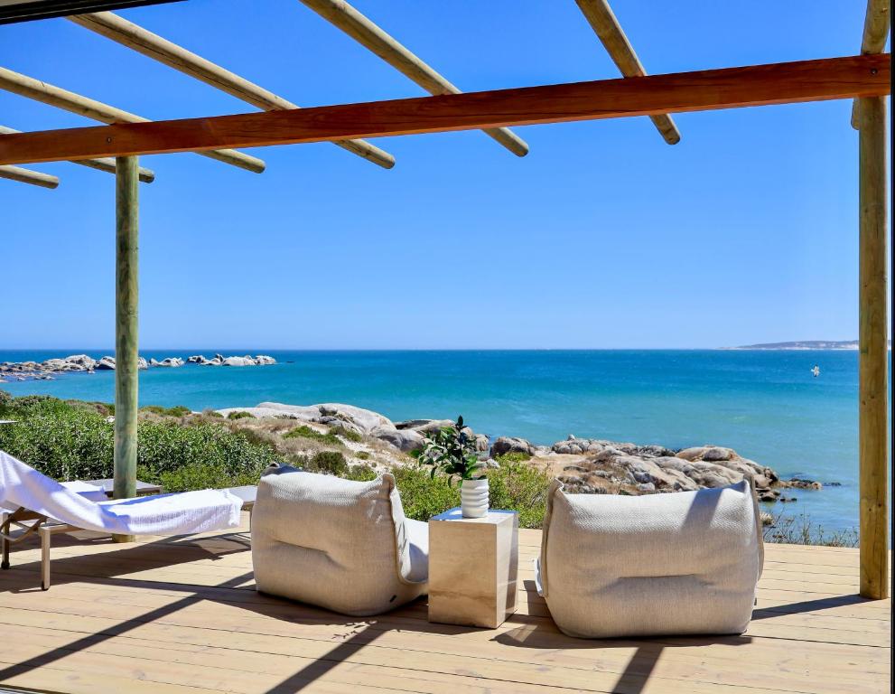 d'une terrasse avec des chaises et l'océan en arrière-plan. dans l'établissement La Baleine, à Paternoster
