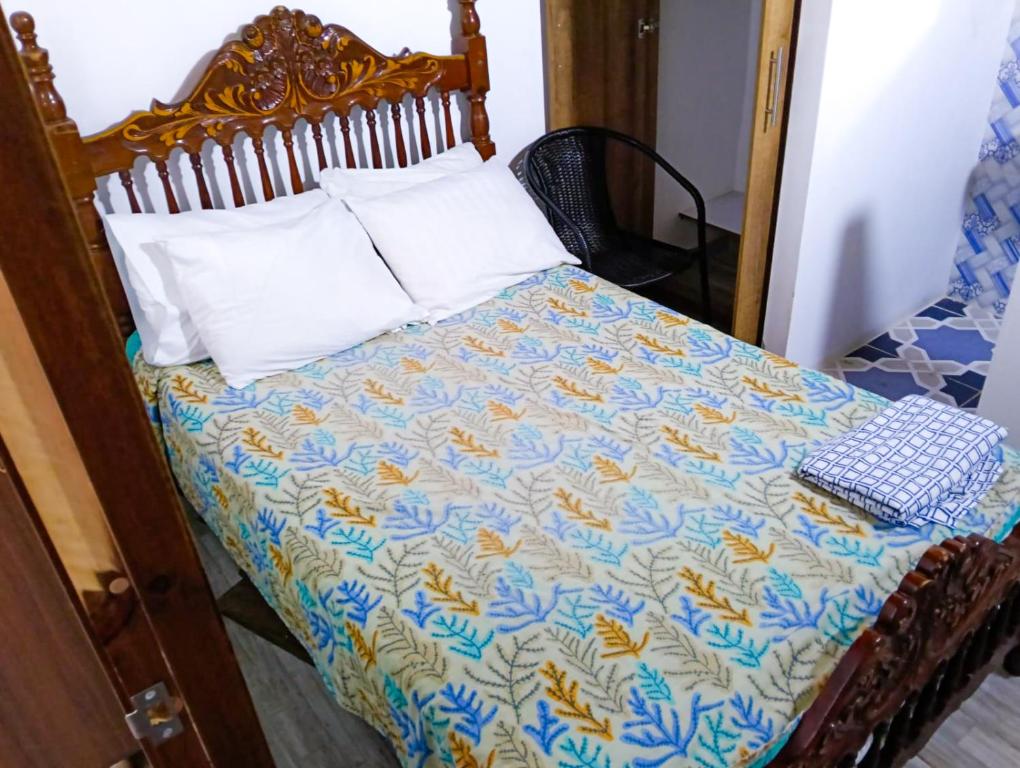 a bed with a quilt and pillows on it at habitacion en casa de familia in Rionegro