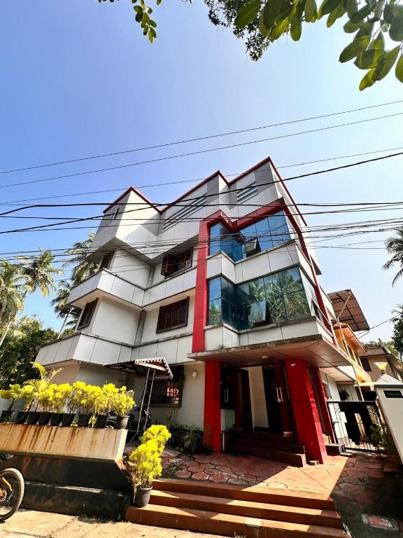 a white and red building with flowers in front of it at devanjana inn in Jāmb
