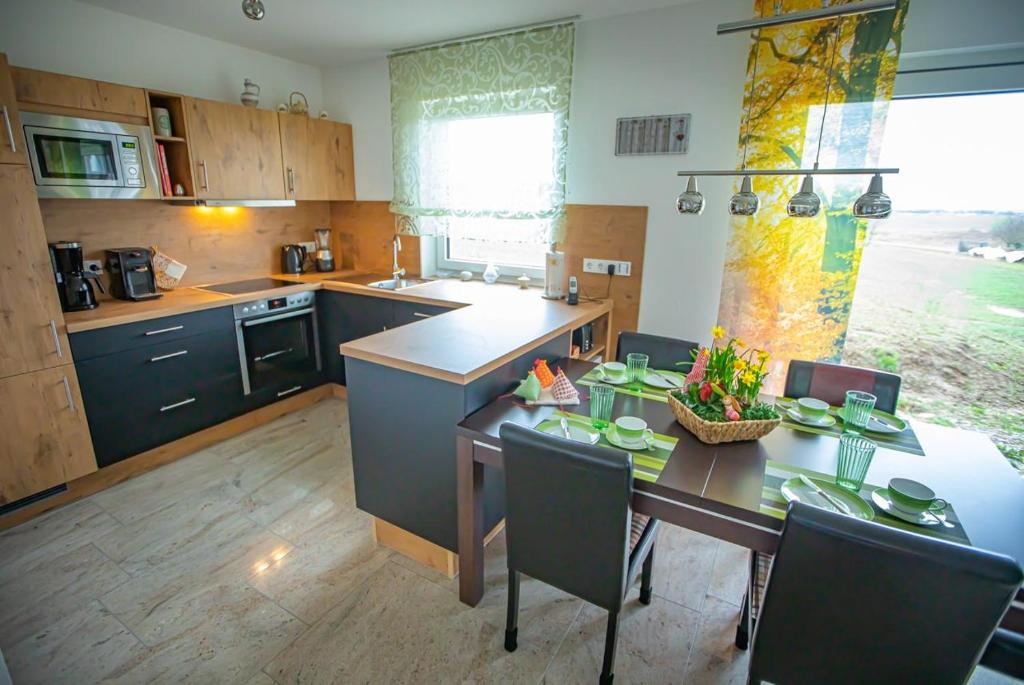 eine Küche mit einem Tisch und Stühlen sowie ein Esszimmer in der Unterkunft Wunderschönes Appartement in Oberwaldbach mit Grill, Terrasse und Garten in Burtenbach