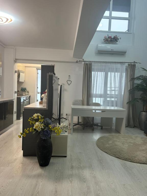 ein Wohnzimmer mit einer Blumenvase auf dem Boden in der Unterkunft Marina Residence 2 in Constanţa