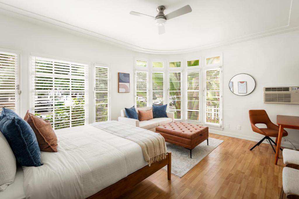 een witte slaapkamer met een bed en een stoel bij Beverly Grove Hotel in Los Angeles