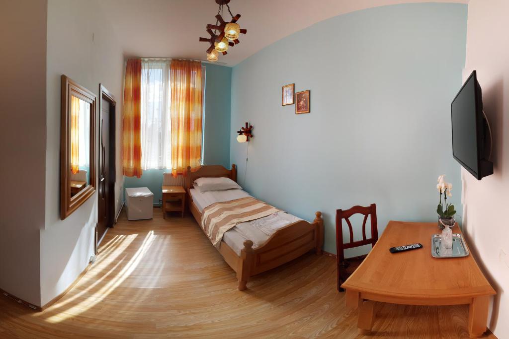 Un dormitorio con una cama y una mesa. en Pensiunea Muresul en Târgu Mureș