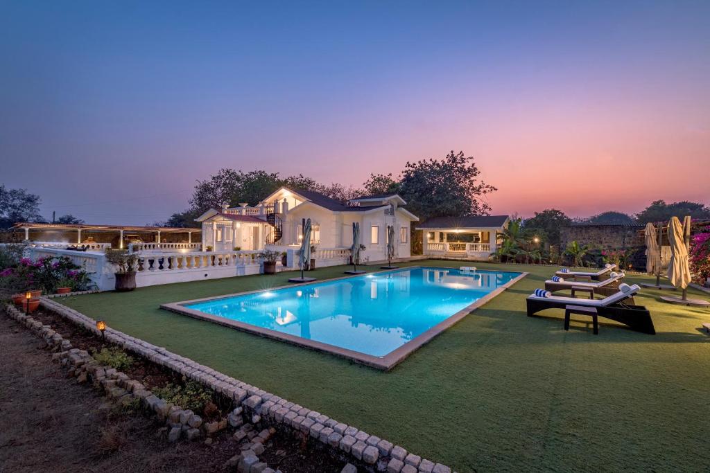 une grande piscine devant une maison dans l'établissement SaffronStays Brunton House, Alibaug - luxury pool villa near Awas Beach, à Alibaug