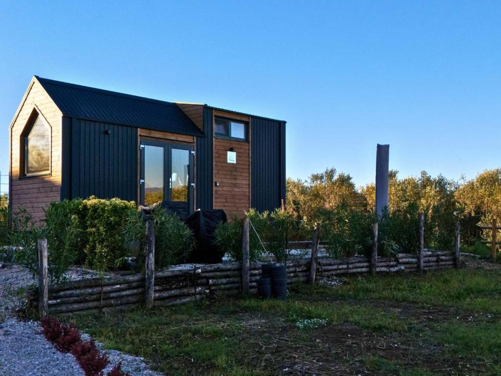 una pequeña casa negra con una valla de madera en Monteleone X by Tiny Away, en Battipaglia