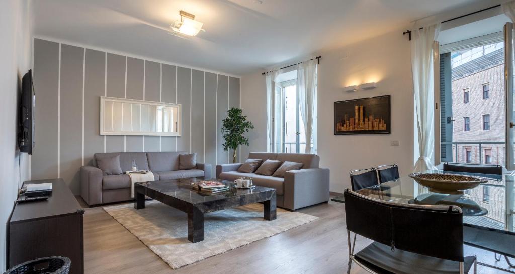 uma sala de estar com um sofá e uma mesa em JOIVY Mazzini Brera em Milão
