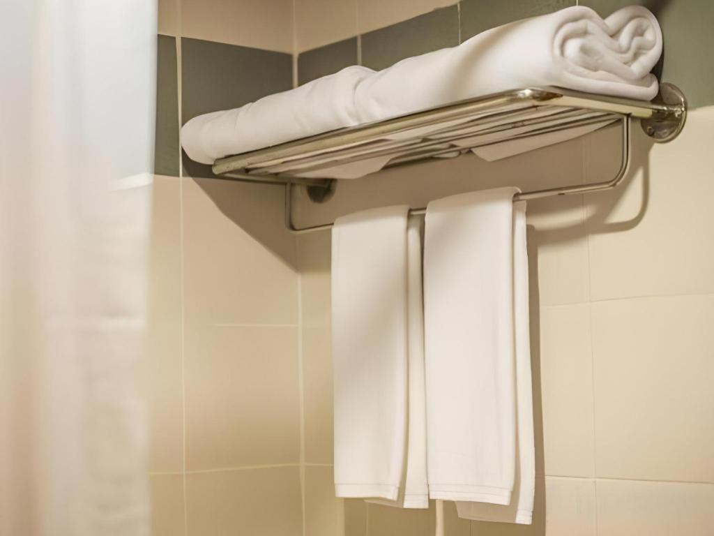 a towel rack with white towels on it in a bathroom at K.P. Grand Hotel Chanthaburi in Chanthaburi