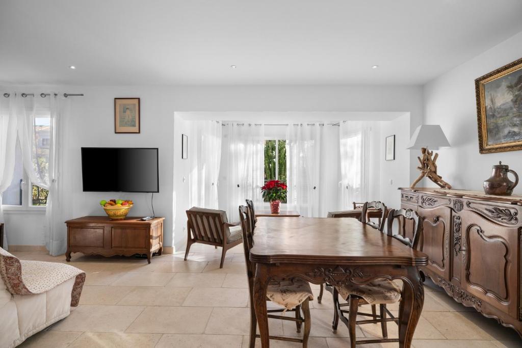 a living room with a wooden table and chairs at Luxueux appartement près du port in Sanary-sur-Mer