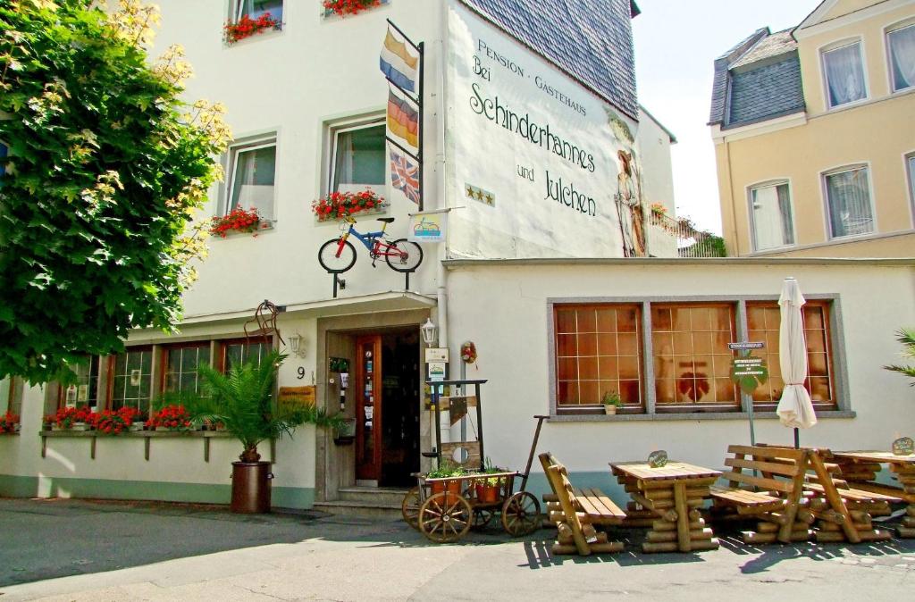 ein Gebäude mit einem Tisch und einem Fahrrad an der Wand in der Unterkunft Pension bei Schinderhannes und Julchen in Boppard