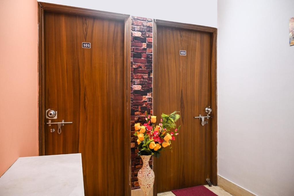 a vase of flowers sitting in front of a door at Hotel O Shraddha Residency 2 in Pānchuria