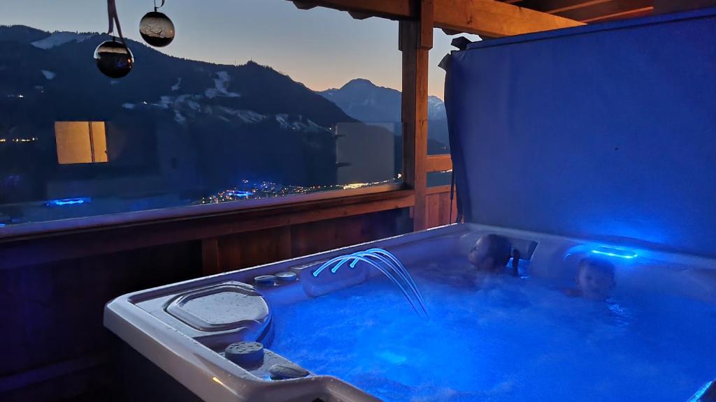 un homme dans une baignoire remplie d'eau bleue dans l'établissement Ferienwohnung La-Wurm mit privatem Whirlpool, à Hart im Zillertal