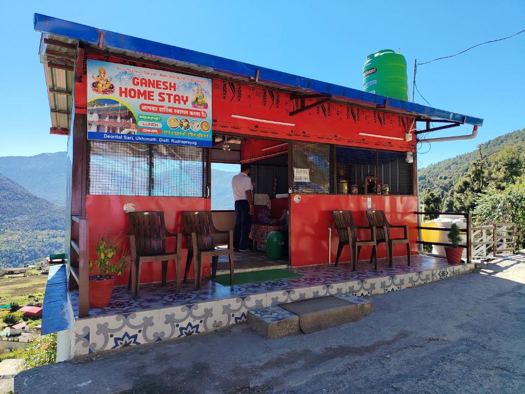 una casa de huéspedes roja con sillas en el exterior en Shri Ganesh Home stay, en Ukhimath
