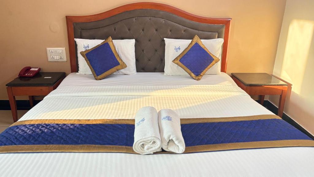 Un dormitorio con una cama con dos pantuflas encima. en Hotel Chetan International, en Bangalore