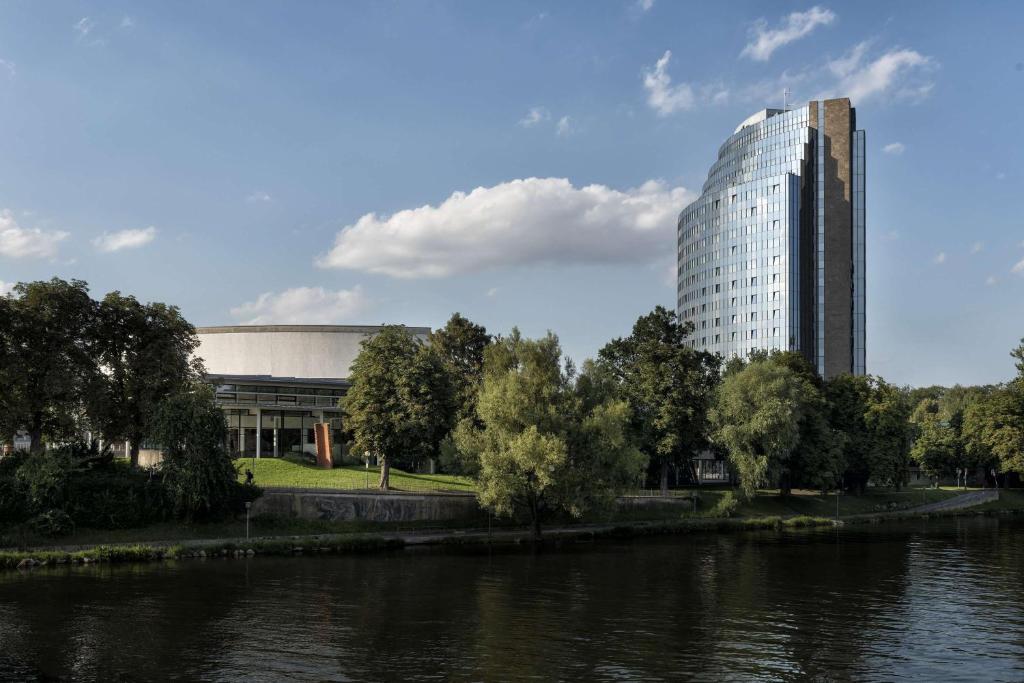 un edificio alto junto a un río con un edificio en Maritim Hotel Ulm en Ulm