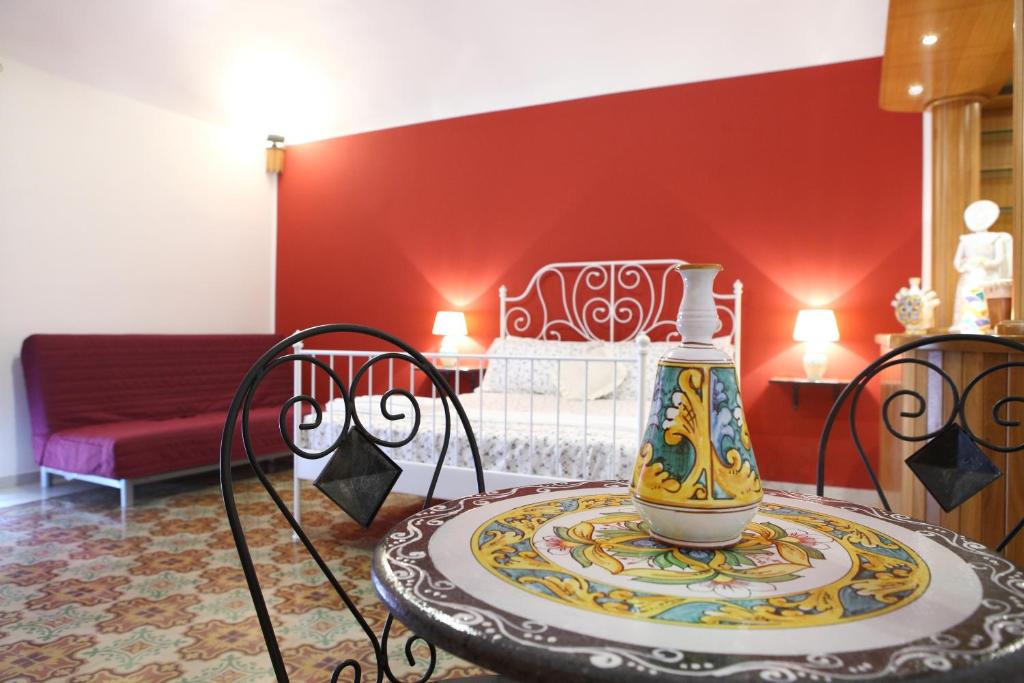 ein Zimmer mit einem Tisch und einer Vase darauf in der Unterkunft B&B Maia House in Santo Stefano di Camastra