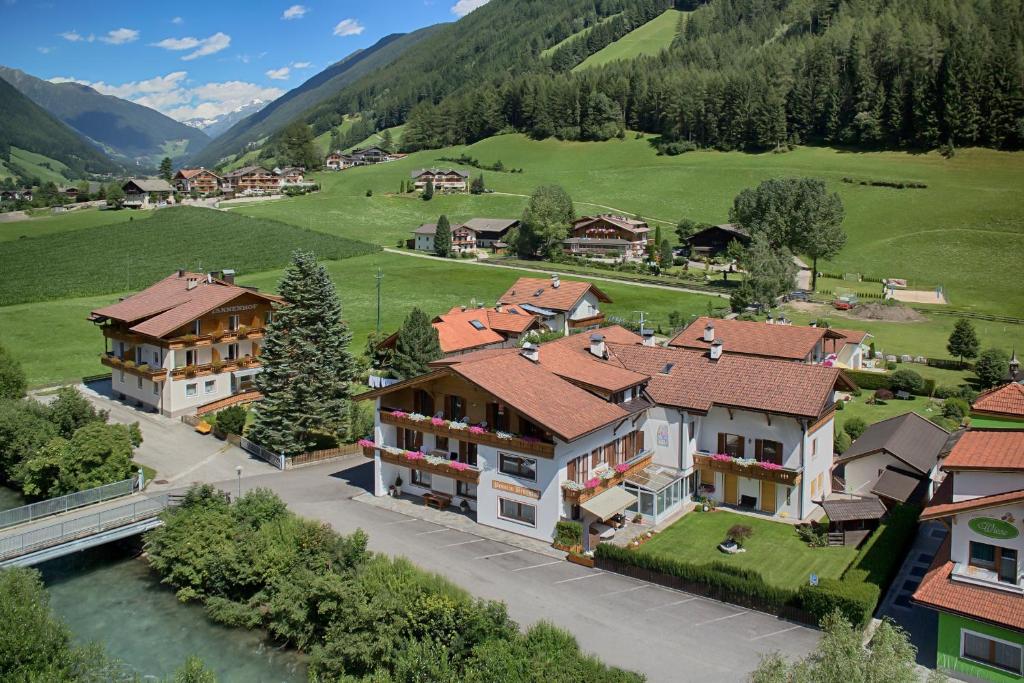 an aerial view of a village with houses and a river at Pension Brugghof in San Giovanni in Val Aurina