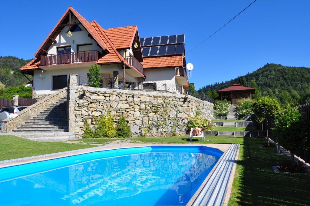 a house with a swimming pool in front of it at Willa Nad Wodospadem in Szczawnica