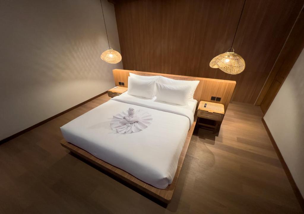金巴兰Kinama Villa的卧室里有一张床，床单和枕头都是白色的