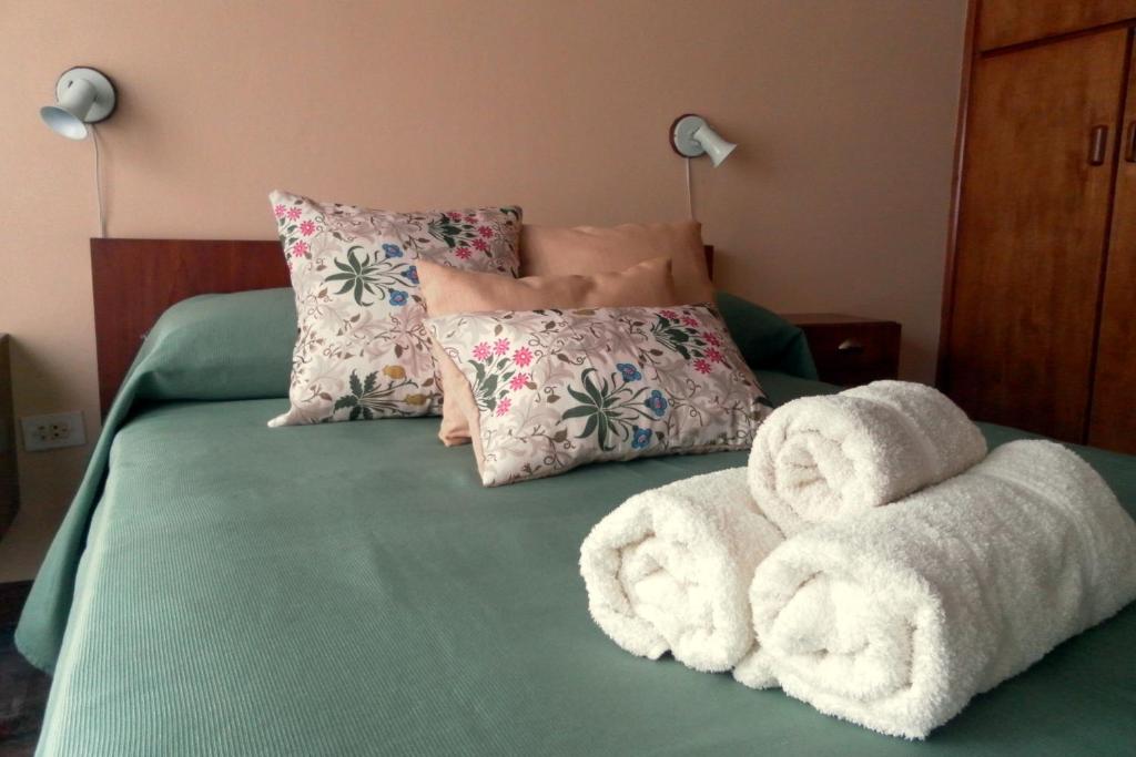 uma cama com uma pilha de toalhas em Amapolas Huéspedes em Tandil