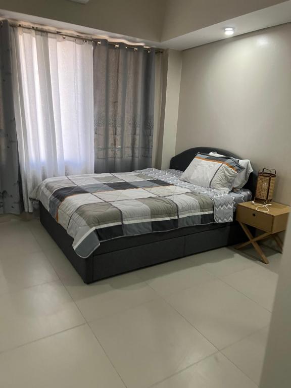 a bedroom with a bed and a window at baseline prestige in Cebu City