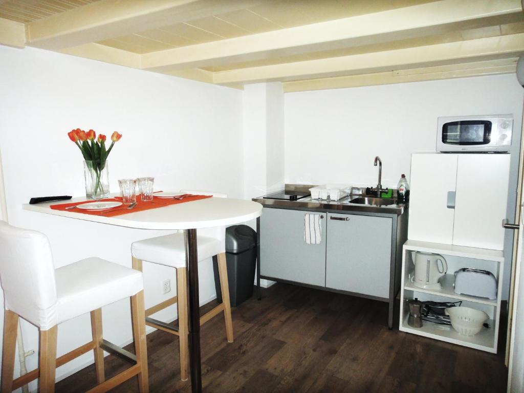 cocina con mesa blanca y nevera blanca en Orange Suite Studio, en Ámsterdam