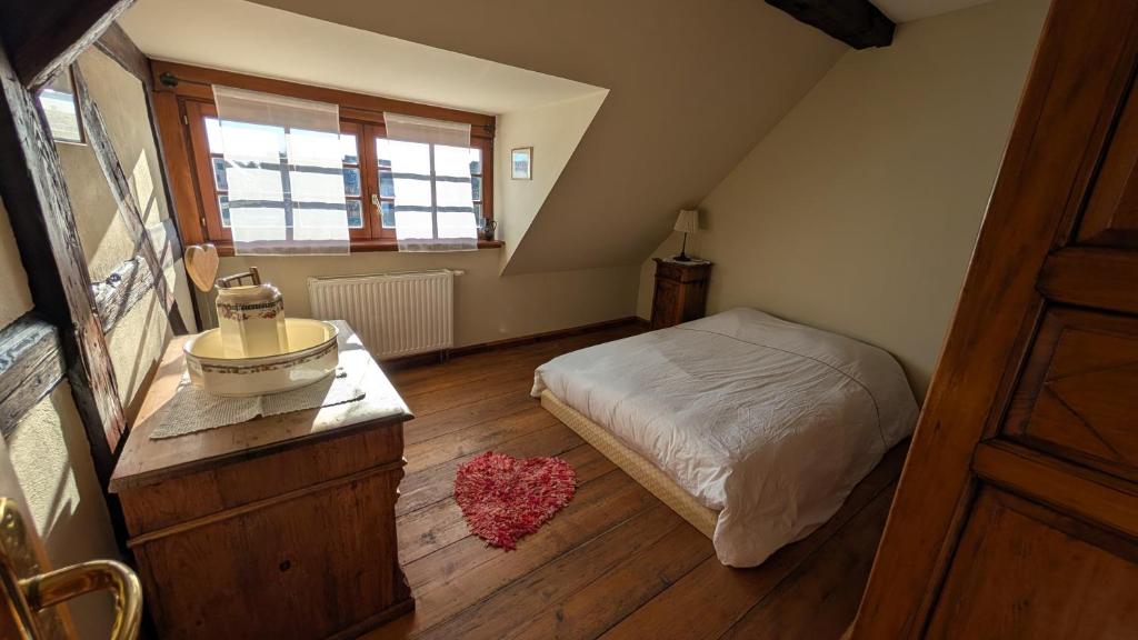 a bedroom with a bed and a wooden floor at Les Perles du Ried - Gîte 209 in Boofzheim
