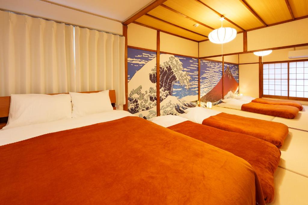 a bedroom with two beds and a large window at 畳庵嵐山 in Kyoto