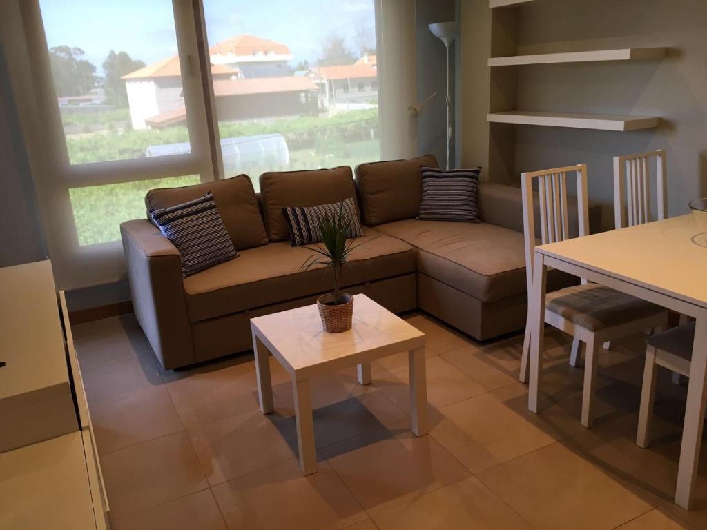 sala de estar con sofá y mesa en Apartamentos Lanceata I, en A Lanzada