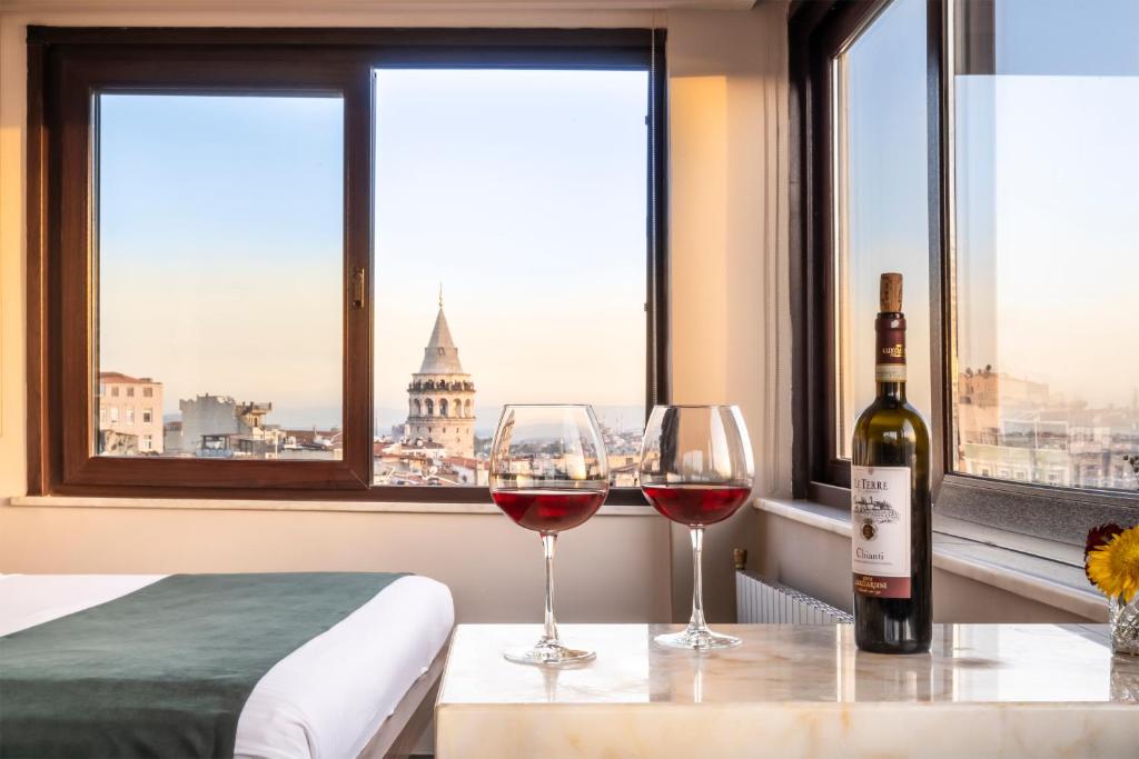 two glasses of wine sitting on a table in front of a window at The Pera Hotel in Istanbul