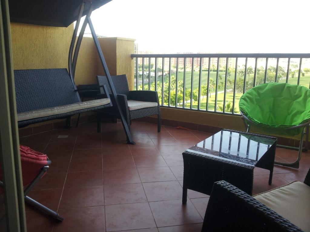 a room with a balcony with chairs and a table at Apartment in Golf Porto Marina in El Alamein