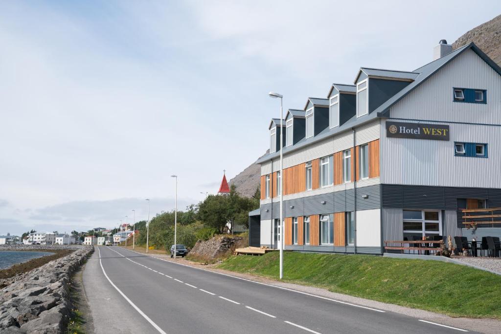 un bâtiment situé sur le côté d'une route dans l'établissement Hotel West, à Patreksfjörður