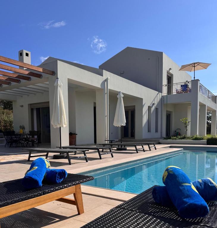 a swimming pool with blue infront of a house at Villa Paradisio in EFL